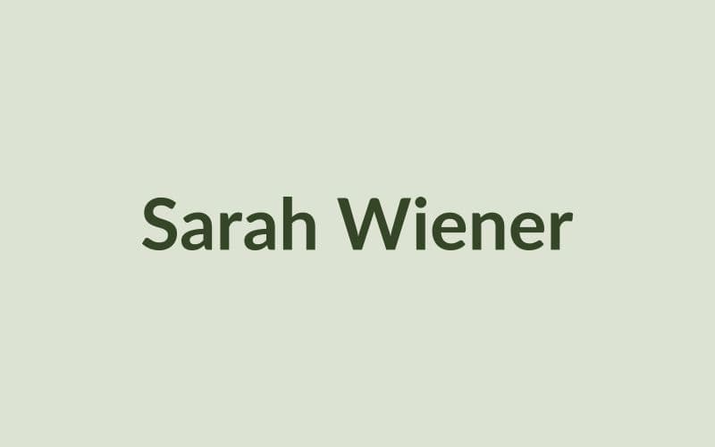Köchin Sarah Wiener arrangiert Chicorée und Radicchio auf einem hellen Holzbrett